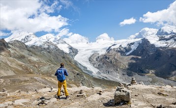 Hiker looks from the mountain Unterrothorn onto the glacier tongue of the Findel Glacier