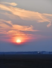 Airplane on the runway at sunset