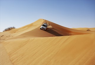 Off-road vehicle drives on a sand dune