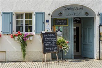 Entrance to the restaurant with menu and flower arrangements