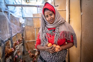 Ethiopian farmer woman holding eggs from her chicken coop