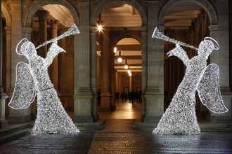 Two angels illuminated for Christmas in front of the Mill Colonnade