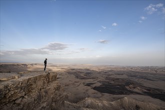 Tourist standing on rock at Maktesh Ramon Crater