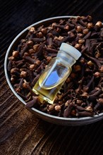 Cloves in a bowl and clove oil