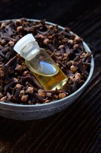 Cloves in a bowl and clove oil