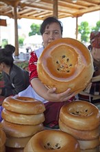 Woman shows a traditional Samarkand bread