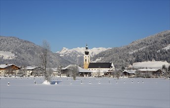 Village with parish church in winter