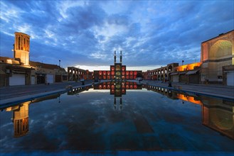 Amir Chaqmaq complex facade illuminated at sunrise and reflecting in a pond