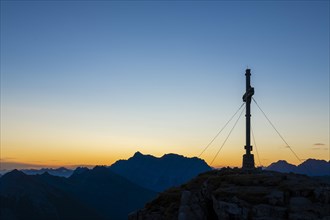 Sunrise with cross of the Thanell summit and Lechtal Alps