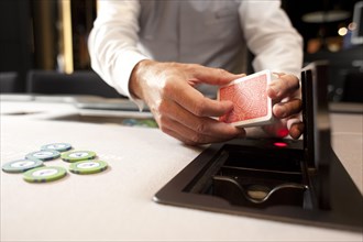 Casino employee holding a deck of playing cards