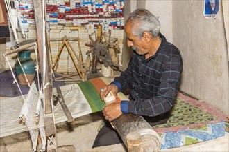 Iranian man working on a loom