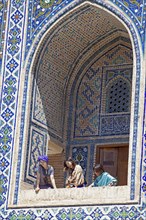 Uzbek women in an ogival niche of the Ulug'Bek Medrese