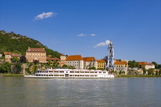 Excursion boat on the Danube in front of the baroque church of the monastery Duernstein