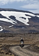 Motorbike on gravel road in desert-like landscape in the highlands in summer