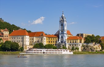Excursion boat on the Danube in front of the baroque church of the monastery Duernstein