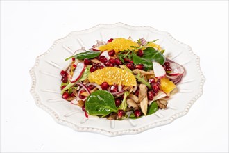 Served salad on a porcelain plate with orange slices