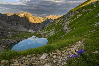 Mountain trail with Lake Guffelsee and Lechtal Alps in the morning light Gramais