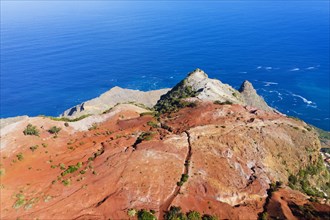 Eroded mountain slope with red earth at the coast
