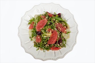 Served salad on a porcelain plate with grapefruit