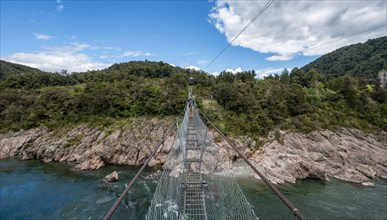 Young man on suspension bridge over Buller River