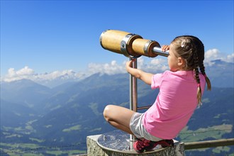 Girl looking through a wooden telescope
