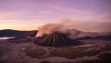 Volcanic landscape at sunrise with starry sky
