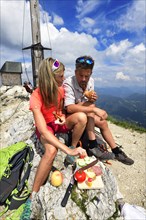Hikers having a snack on the summit of the Geigelstein