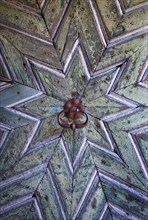Old wooden house door with star-shaped pattern on a historic farmhouse