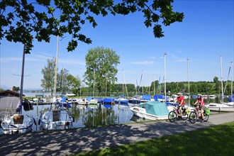 Couple with electric bikes in the port of Matzing on Lake Wallersee