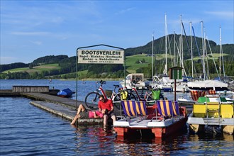 Couple with electric bikes pauses on a landing stage at Lake Obertrumer See
