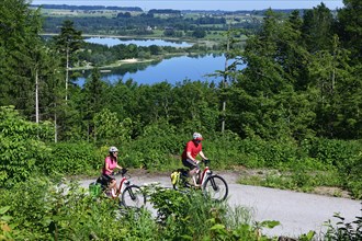 Couple with electric bikes riding above Lake Mattsee