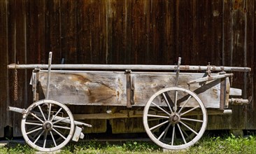 Historical cart stands in front of a barn