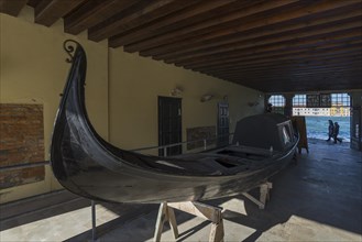 Discarded covered gondola in the entrance of a boatyard