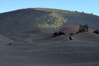 Wandering woman in volcanic lunar landscape