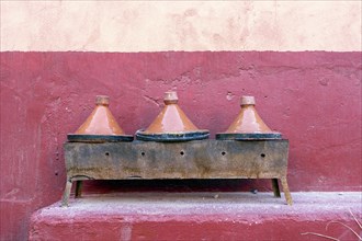 Three clay tagine pots on portable barbeque