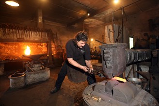 Blacksmith at the forge hammer