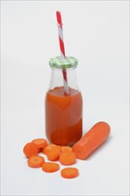 Carrot juice in bottle and carrot slices