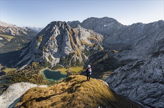 Young woman with climbing helmet looking at Seebensee from the Ehrwalder Sonnenspitze