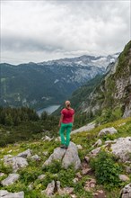 Hiker looks at Vorderer Gosausee and Dachstein massif