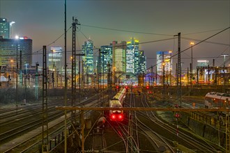 Train and tracks in front of main station and skyline Frankfurt Main in the evening at Hochnebel