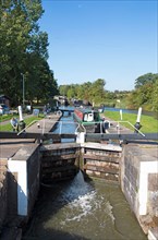 Woman opening a lock for a narrowboat or canal boat on the Grand Union Canal