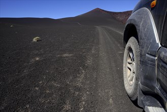 All-terrain vehicle on the road through volcanic lunar landscape