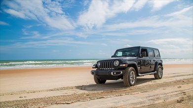 Jeep Wrangler drives over beach