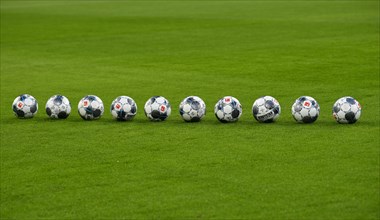 10 match balls adidas Derbystar lie in a row on the turf of the Allianz Arena
