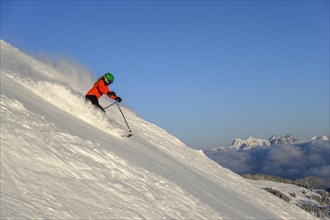 Female skier descending steep slope