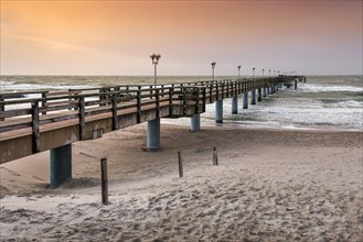 Pier on the beach of the Baltic Sea at sunset