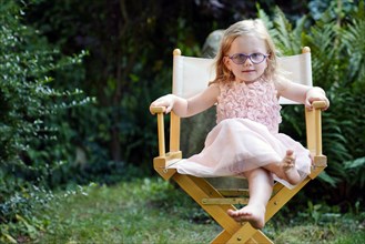 Portrait 3 years old girl sitting in garden chair