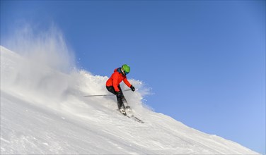 Skier descending steep slope