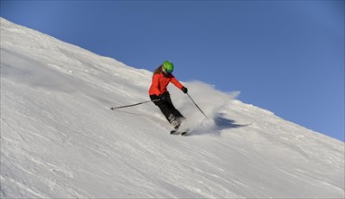 Skier descending steep slope