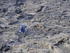 Motocross rider in steep rocks